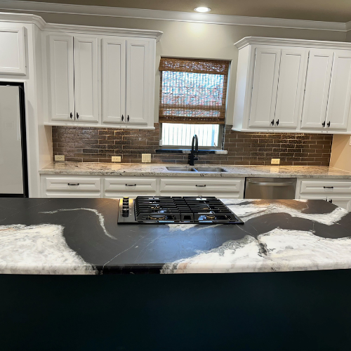 black and white marble countertops in a kitchen with white cabinetry
